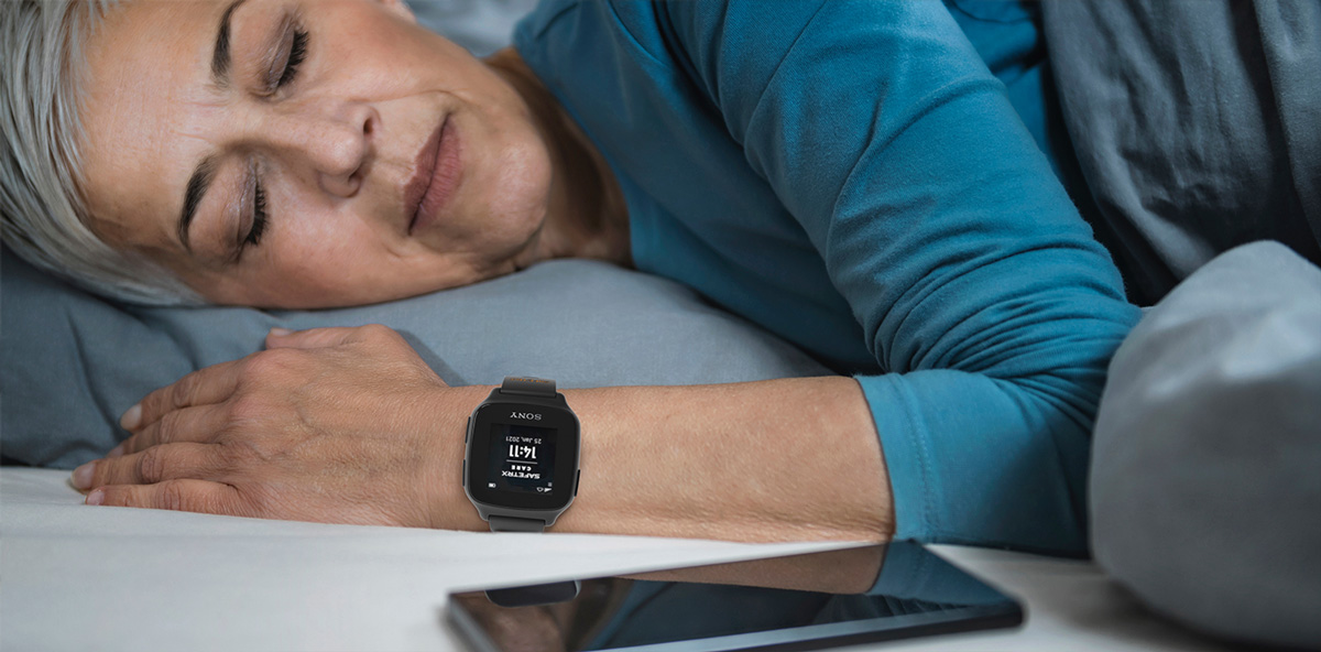 Elderly woman sleeping and wearing SafeTrx wearable by Sony